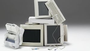 Vecchi monitor del PC, stampante e tastiera accatastati