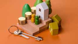 Casa, chiavi e monete per rappresentare il costo di mutui e prestiti alle famiglie