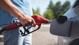 Automobilista fa rifornimento mentre il Brent scende verso 86 dollari