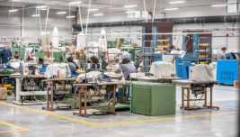 Operai al lavoro in uno stabilimento manifatturiero con macchinari industriali