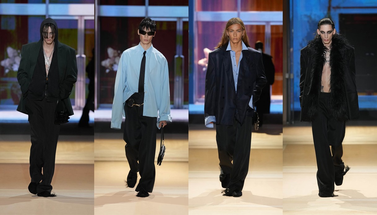 Collage di quattro uscite in passerella: giacca scura con cappuccio e collane, camicia azzurra oversize con cravatta, giacca doppiopetto ampia e cappotto con collo in piume nere