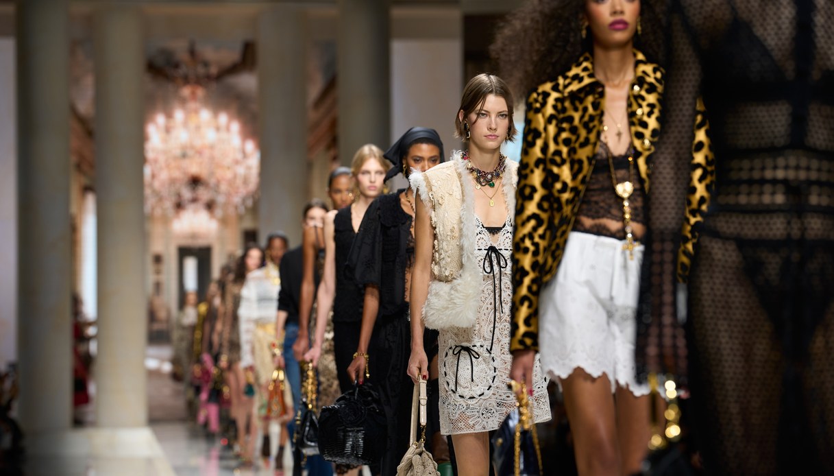 Uscite in passerella ravvicinate con abito bianco all'uncinetto e gilet in pelliccia, giacca animalier su top in pizzo nero e shorts in sangallo bianco