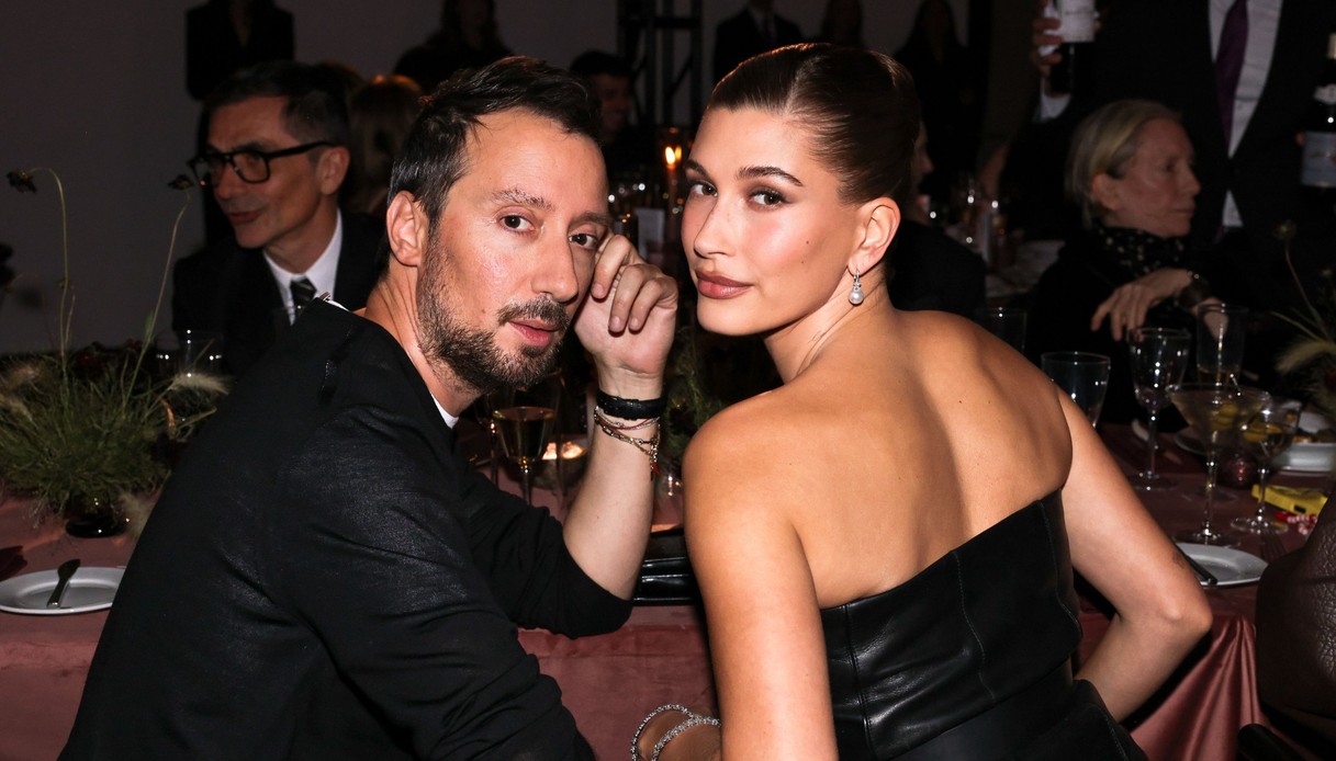 Anthony Vaccarello in maglia nera e Hailey Bieber in abito di pelle nera a fascia, seduti a tavola durante la cena dei WSJ. Magazine Innovator Awards al MoMA di New York