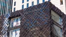 Facciata di un negozio Burberry con insegna e rivestimento metallico geometrico