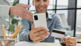 Cliente utilizza smartphone e carta per effettuare un pagamento digitale